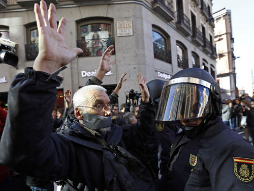 Một người biểu tình đối mặt với cảnh sát tại Madrid 
