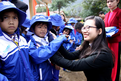 Bà Nguyễn Thu Hằng, đại diện Công ty TNHH Amway VN trao áo ấm cho các em học sinh vùng cao