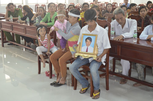 Vợ anh Sang mang theo hai con nhỏ và di ảnh chồng vào tận bệnh viện khiếu nại - Ảnh: Thanh Đức