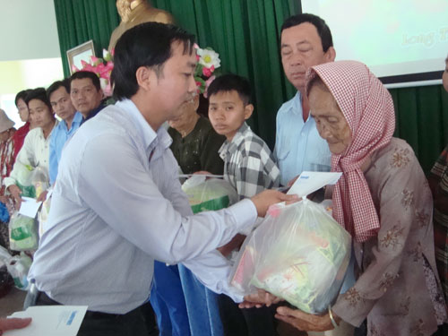 Ông Nguyễn Văn Bé Thanh, Phó chủ tịch UBND xã Long Thới, H.Nhà Bè tham gia trao quà cho các hộ dân sáng qua - Ảnh: Thanh Đông