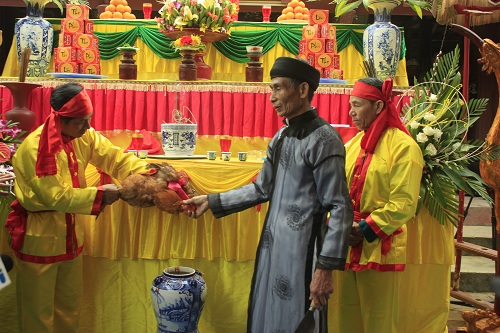 Ông Phạm Phú Oanh là chủ lễ của hội Minh Thề cắt tiết gà trống hòa vào hũ rượu - Ảnh: V.N.K