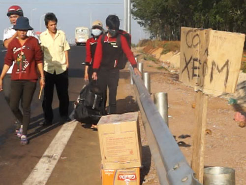 Hành khách bị nhà xe bỏ rơi, đi bộ trên đường cao tốc để đón xe về Biên Hòa - Ảnh: Thanh Chương