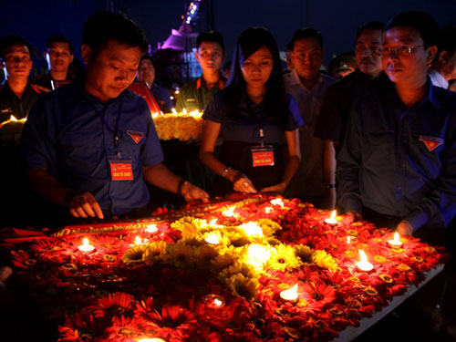 Anh Đặng Quốc Toàn, Bí thư T.Ư Đoàn (bìa phải) thả hoa tri ân các anh hùng liệt sĩ bên dòng Bến Hải - Ảnh: Nguyễn Phúc