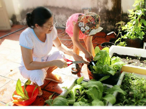 Chị Đoàn Diễm cùng bé Bòn Bon thích thú với công việc làm vườn - Ảnh: Thanh Đông