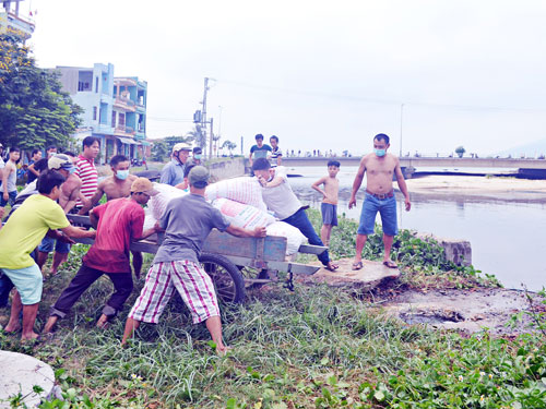 Người dân kéo nhau lấp cống xả ra sông Phú Lộc	- Ảnh: Nguyễn Tú