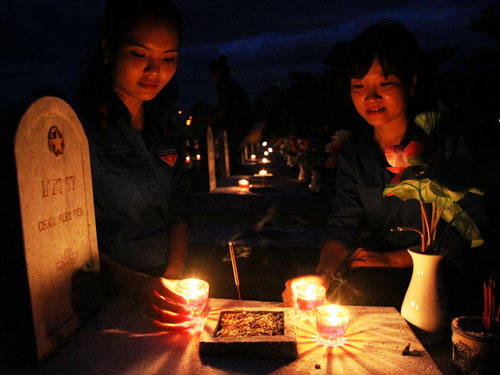 Bạn trẻ thắp nến tri ân tại Nghĩa trang liệt sĩ quốc gia đường 9 - Ảnh: Nguyễn Phúc