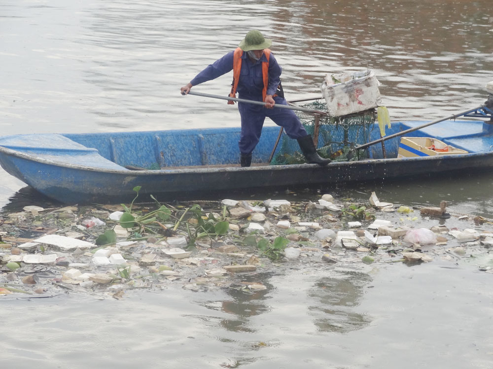Công nhân cật lực vớt rác thải trên kênh Tẻ - Ảnh: Đ.Mười