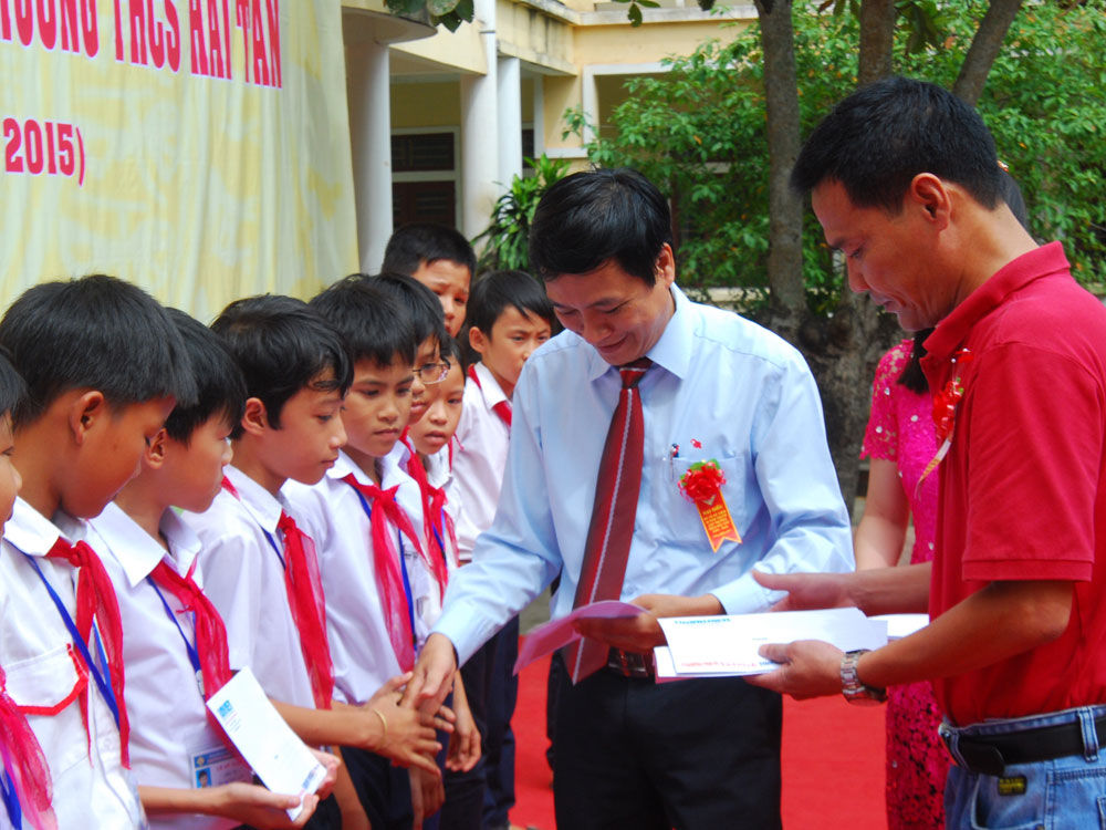 Trưởng phòng Giáo dục - Đào tạo H.Hải Lăng và đại diện Báo Thanh Niên trao học bổng cho các học sinh - Ảnh: Tấn Cư