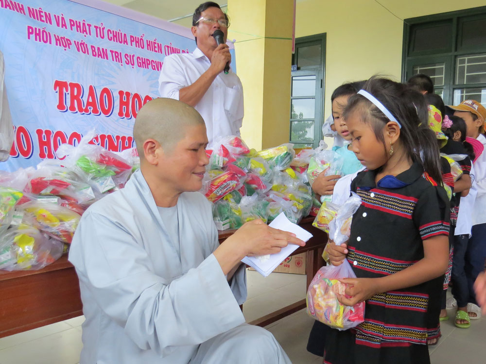 Ni sư Thích Nữ Tâm Nguyệt trao tiền cho các học sinh Trường tiểu học Hồng Trung