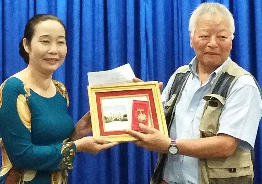 Bà Huỳnh Thị Ngọc Vân, GĐ Bảo tàng Chứng tích chiến tranh đại diện cho thành phố trao tặng Huy hiệu TP HCM cho ông Ishikawa Bunyo