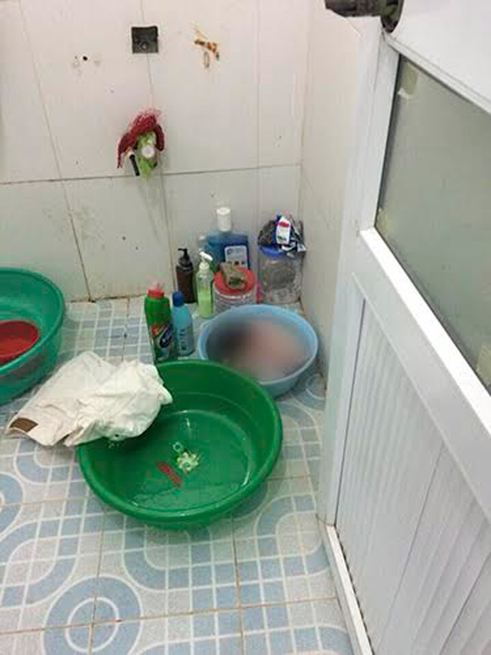 Người dân tìm thấy sản phụ ngất laim và cháu bé đã chết trong phòng tắm ngôi nhà trên đường Nguyễn Viết Xuân - Ảnh: Văn Đông