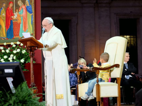 Cậu bé Didier thoải mái ngồi chơi trên ghế giáo hoàng