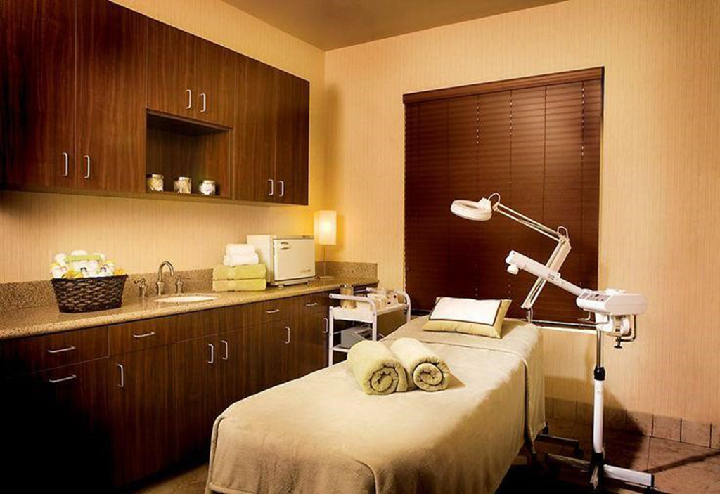 Một phòng spa với đầy đủ giường massage, máy xông, khăn và các phụ kiện spa 