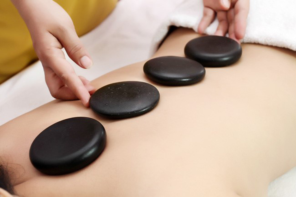 Những viên đá nóng massage được xếp lên người
