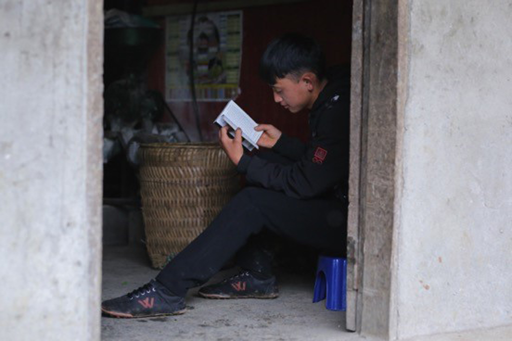 Một bạn trẻ tại một bản nghèo tại Đồng Văn - Hà Giang đọc sách tại gian bếp nhà mình