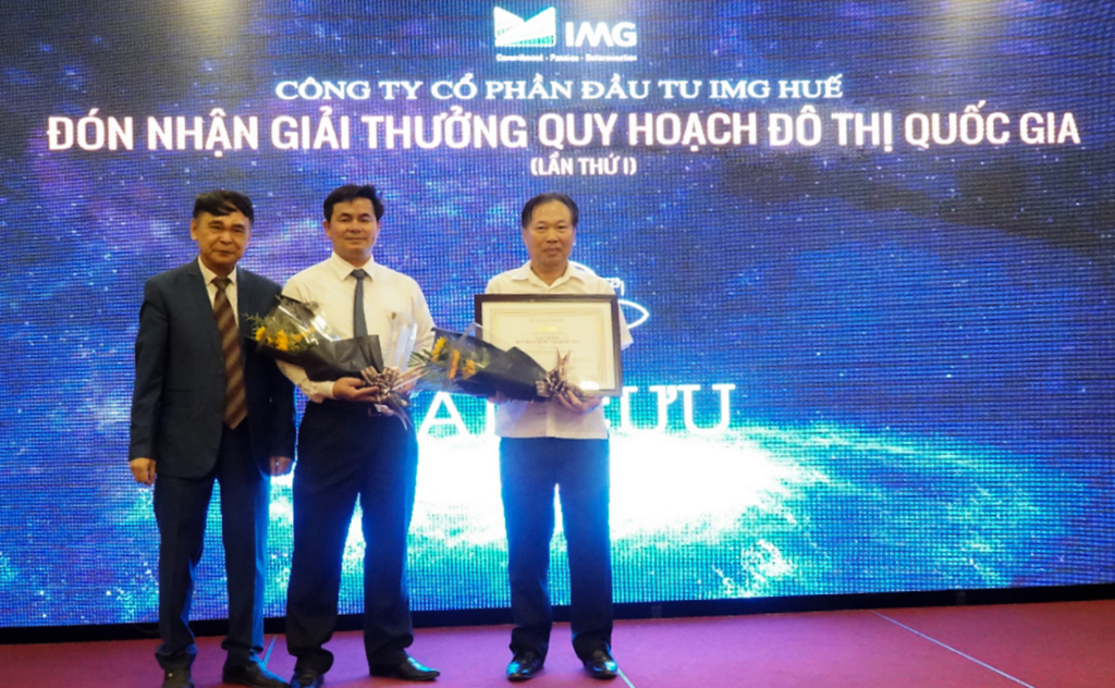   Đại diện IMG Huế, chủ đầu tư dự án An Cựu City Huế (ở giữa và bên phải) nhận cúp và giấy chứng nhận giải thưởng từ Hội Quy hoạch đô thị Quốc gia VN