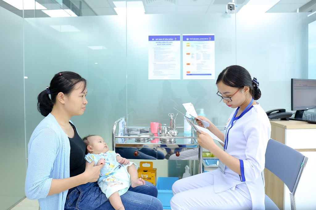 Chuyên viên y tế cung cấp những thông tin liên quan đến vắc xin cho mẹ trước khi tiến hành tiêm vắc xin cho bé