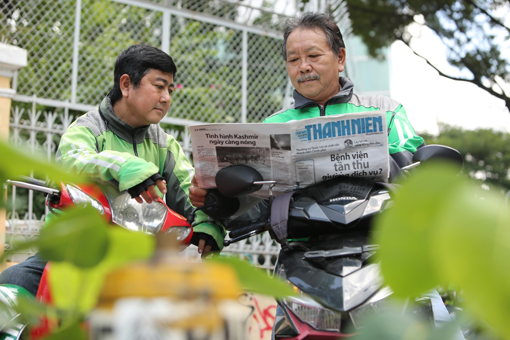 Anh Thanh Long (trái) có thể tránh được nhiều rủi ro khi thường xuyên trao đổi những tin tức về các sự cố liên quan đến xe cộ trên báo với đồng nghiệp 