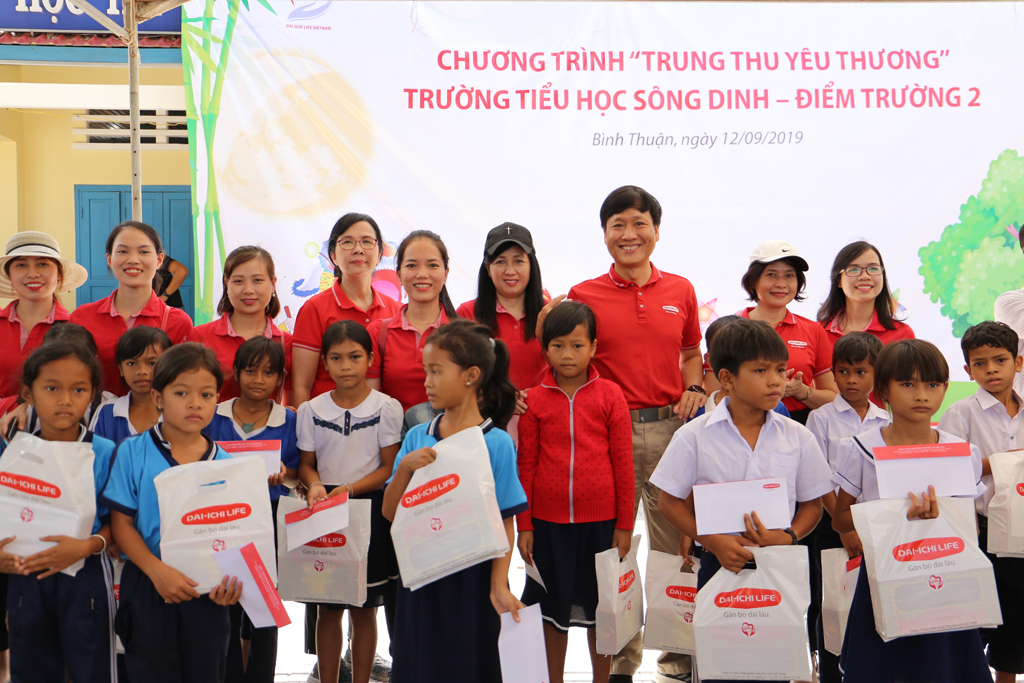 Tổng giám đốc Trần Đình Quân và các thành viên Công ty BNHT Dai-ichi Việt Nam chụp hình lưu niệm với các em học sinh