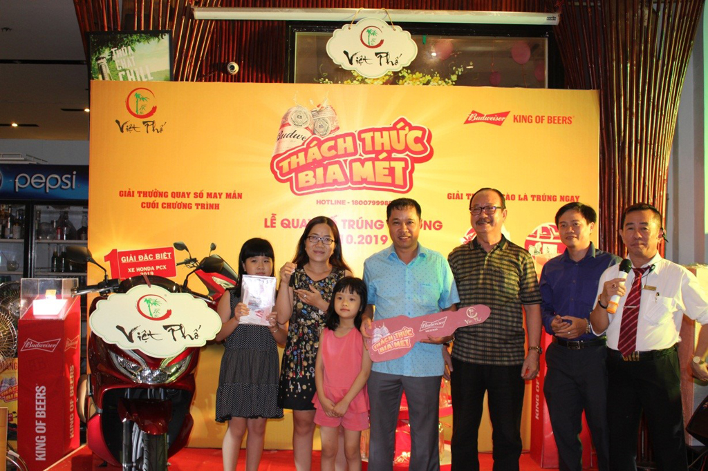 Anh Quang (áo xanh, giữa) được vợ con “hộ tống” đến nhận giải thưởng đặc biệt chiếc xe máy PCX 