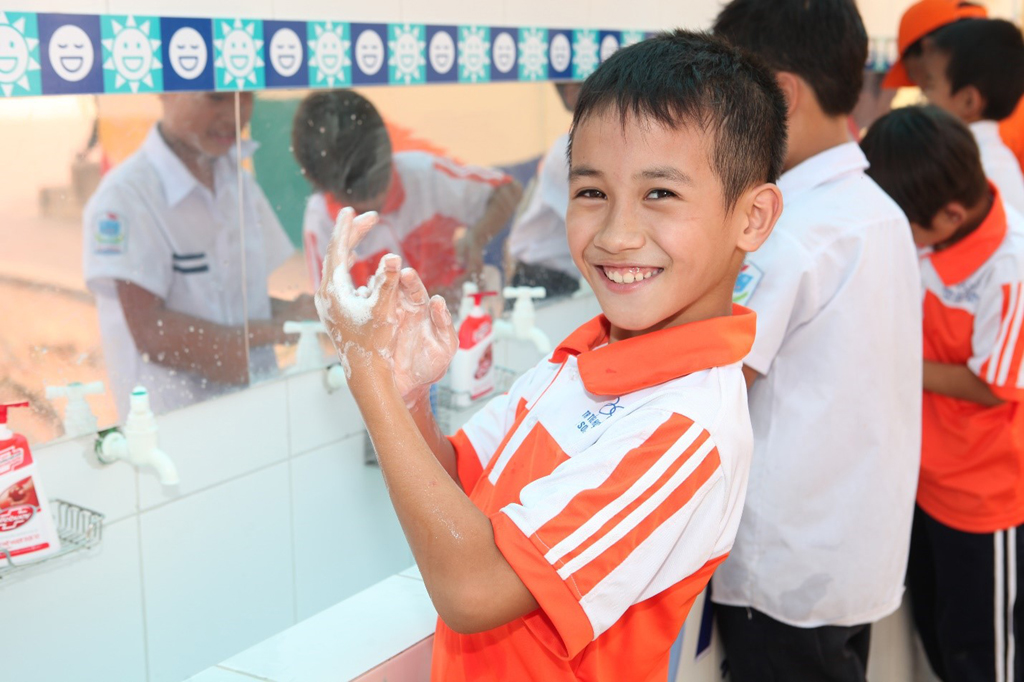 Trẻ em nông thôn được hướng dẫn rửa tay với xà phòng ở bồn rửa tay được xây mới sạch sẽ 