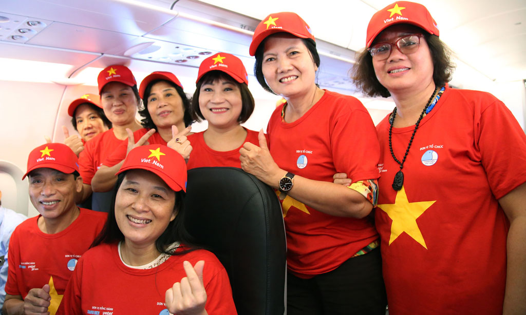 Một nhóm hành khách chụp ảnh kỷ niệm trên tàu bay “Tôi yêu Tổ quốc tôi” của Vietjet  