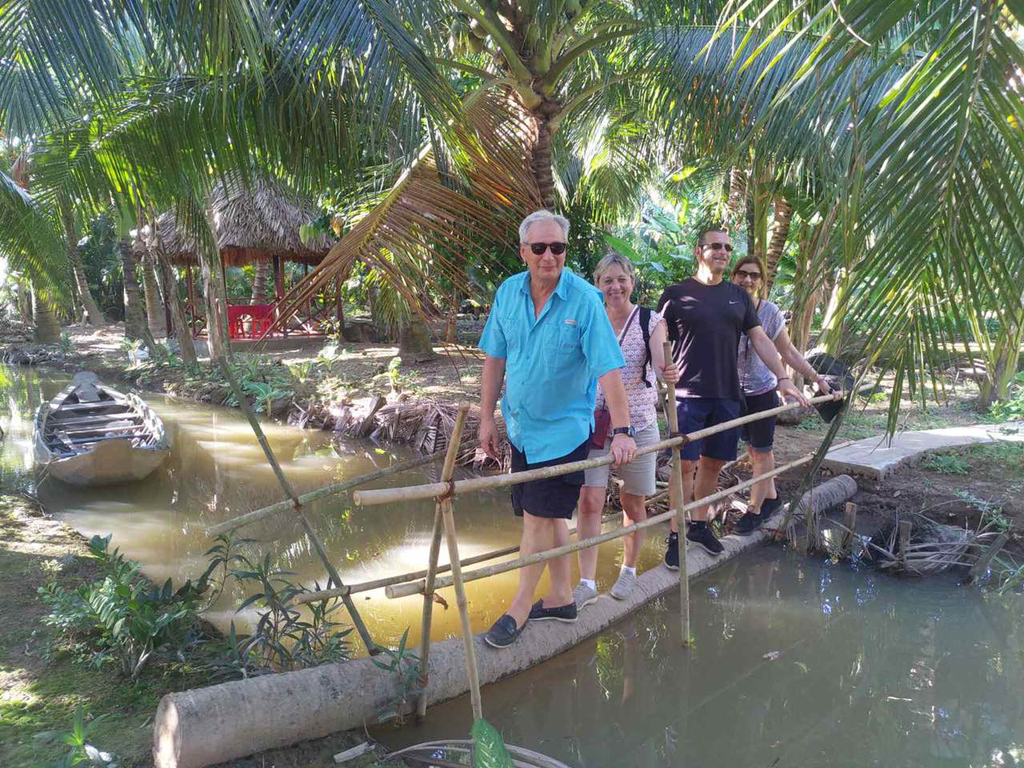 Khách nước ngoài thích thú khi đi qua cầu dừa trong tour Huyền thoại sông Ba Lai