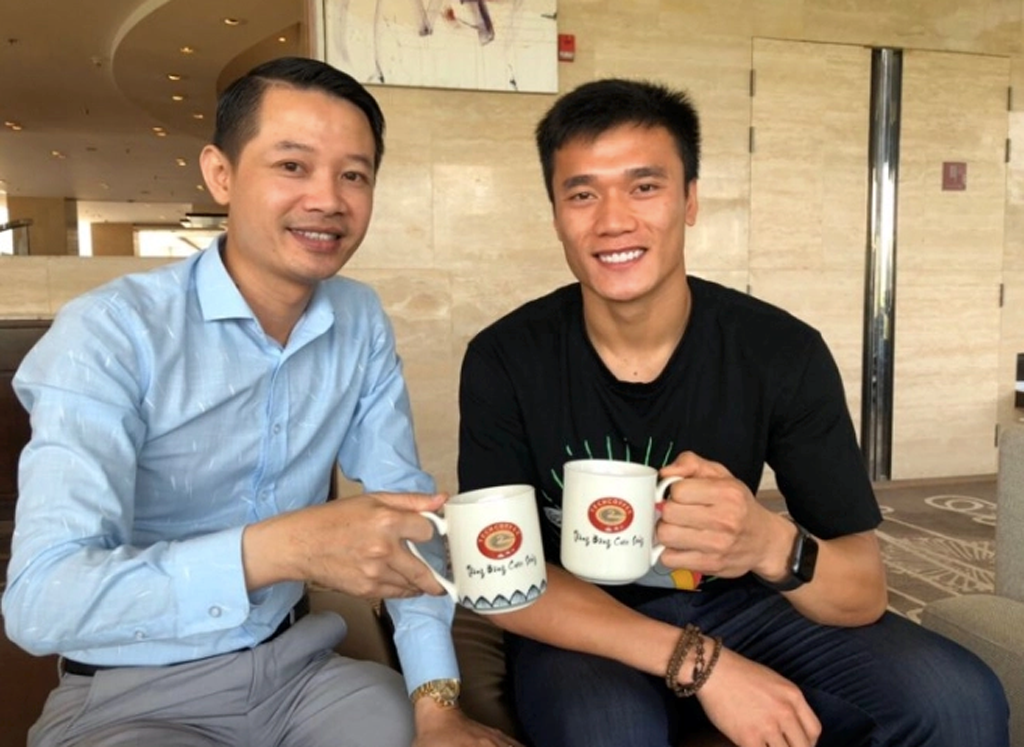  Thủ môn Bùi Tiến Dũng chụp ảnh cùng doanh nhân Phạm Hữu Tuấn bên cốc cà phê của Tech Coffee