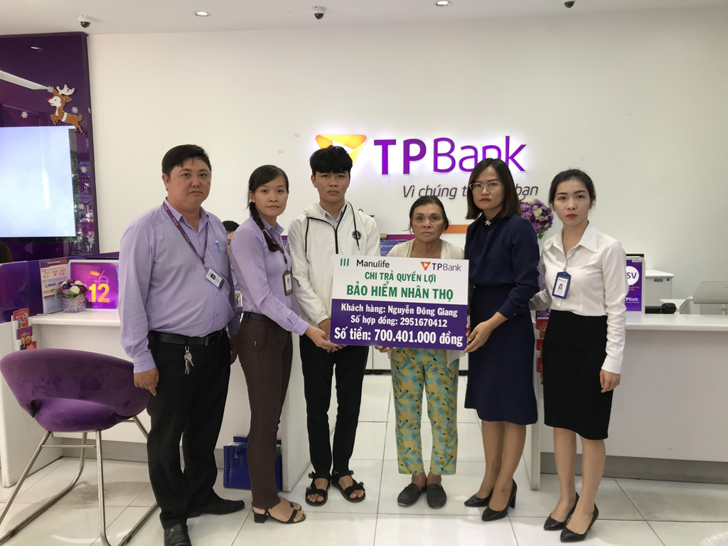 Đại diện Công ty bảo hiểm và ngân hàng TP Bank Nha Trang trao số tiền bảo hiểm cho gia đình anh Giang Ảnh: Hải Thanh 