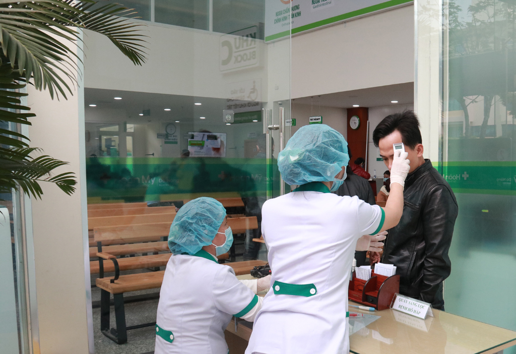 Người bệnh được kiểm tra thân nhiệt, khai báo thời gian lưu trú trước khi tham gia quy trình khám như thông thường Ảnh: Phú Thành