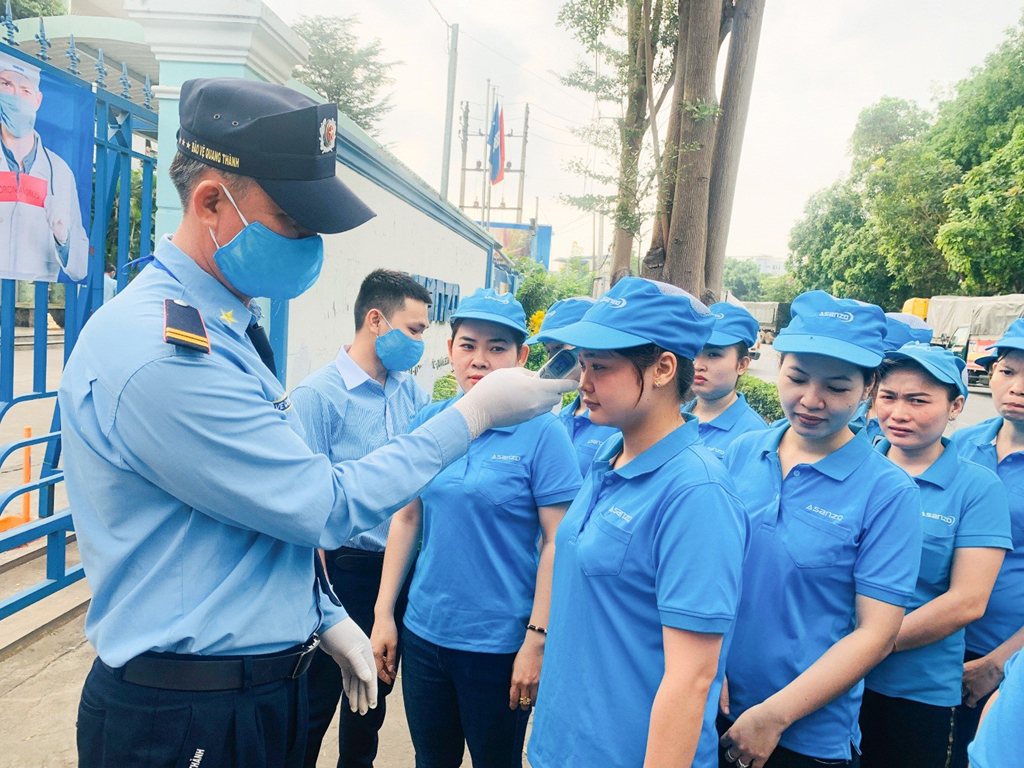 Kiểm tra thân nhiệt, phát khẩu trang cho toàn công nhân trước khi vào nhà máy