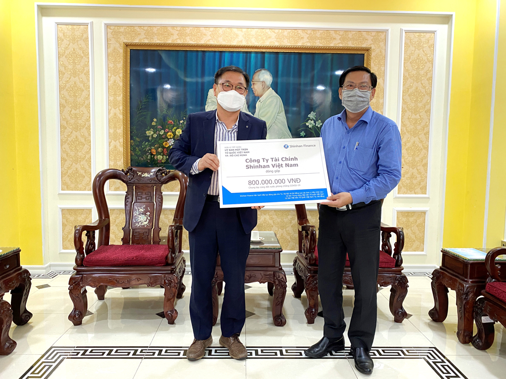 Ông Oh Tae Joon - Phó tổng giám đốc Shinhan Finance trao biểu trưng số tiền đóng góp 800 triệu đồng cho ông Trần Hữu Phước- Đại diện Ủy ban Mặt trận Tổ quốc Việt Nam TP.HCM ngày 31.3