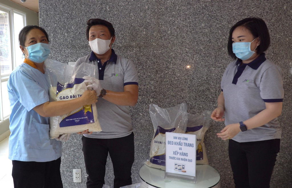 Tập thể nhân viên Bệnh viện JW chung tay hỗ trợ trao những xuất gạo đến tay người dân