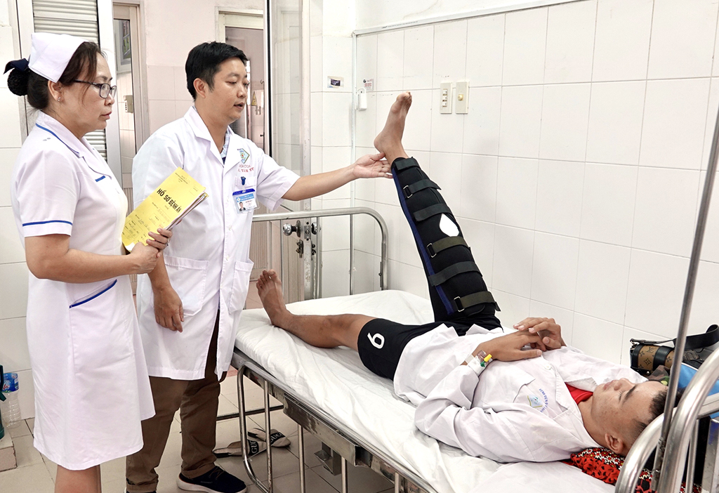 ThS-BS Nguyễn Tâm Từ, Trưởng khoa Phẫu thuật Nội soi - Cổ bàn chân, thăm khám bệnh nhân sau mổ. Ảnh: Đình Tuyển 