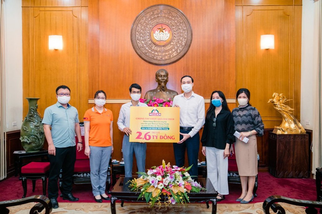 Ông Nguyễn Thịnh Phú - đại diện Tập đoàn Wilmar CLV (trái) trao biểu trưng trị giá 2,6 tỉ đồng của hoạt động ATM di động cho đại diện Ủy ban Trung ương MTTQ Việt Nam