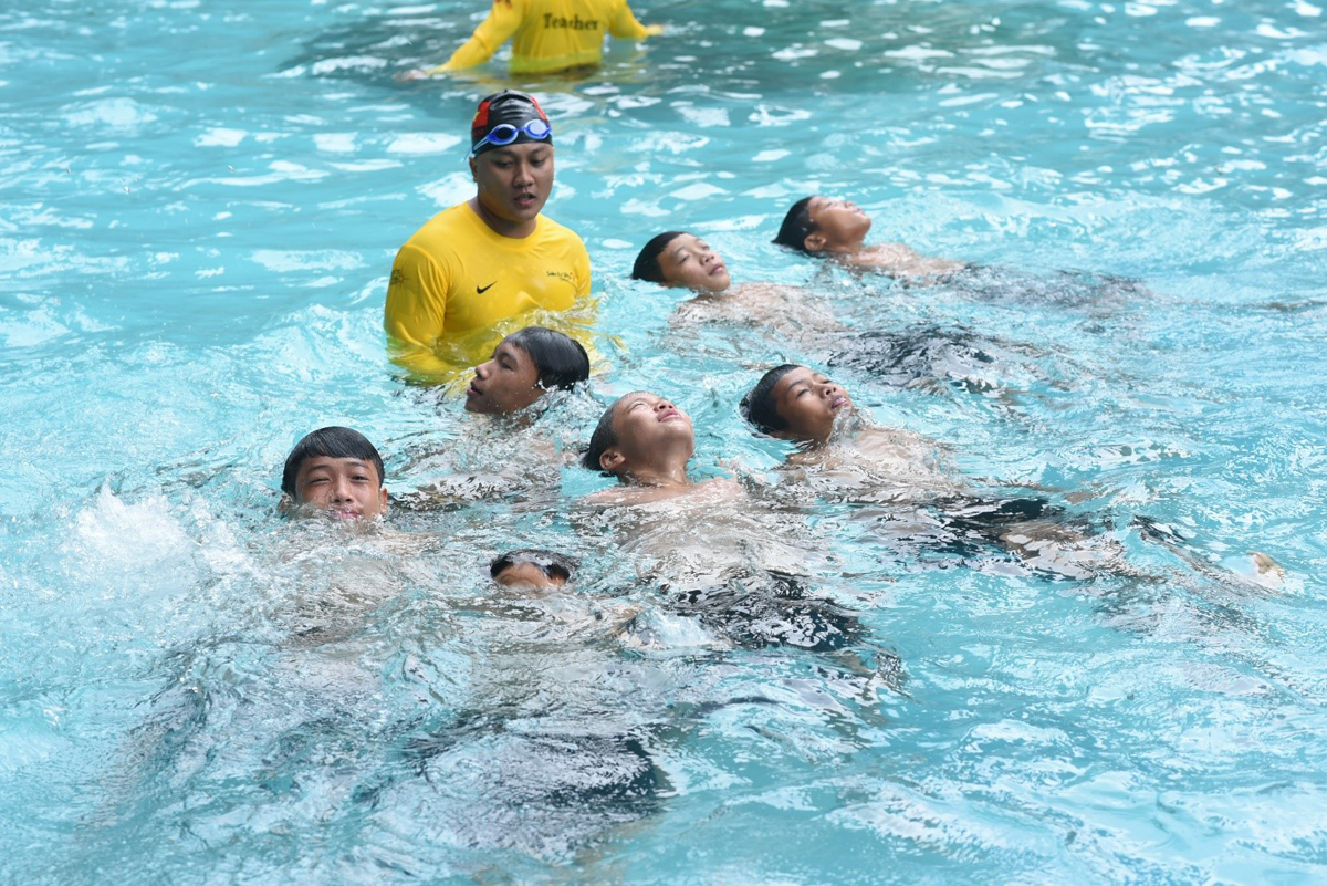 Các em học sinh thực hành kỹ năng bơi an toàn dưới sự hướng dẫn của các chuyên gia đến từ Tổ chức Swim Việt Nam 