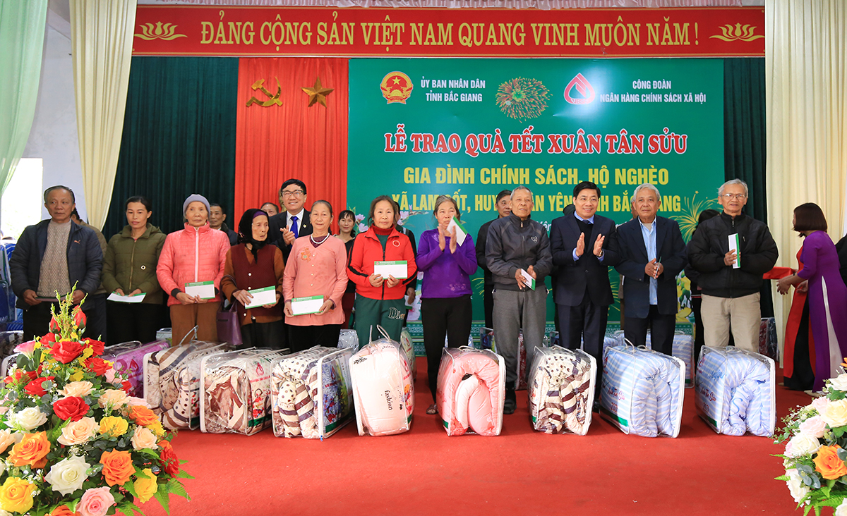 Các gia đình có công với cách mạng, gia đình chính sách và hộ nghèo ở xã Lam Cốt nhận quà tết từ NHCSXH 