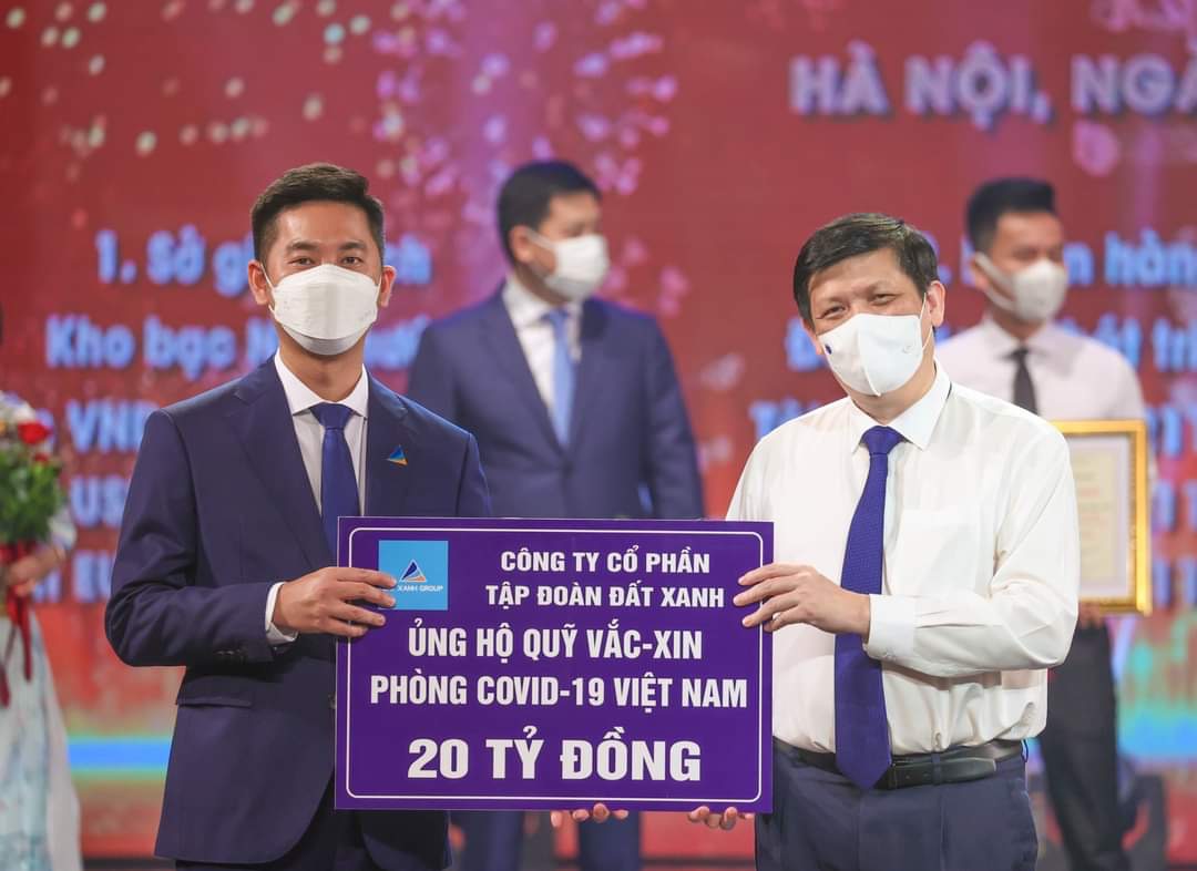 Đại diện Tập đoàn Đất Xanh (bên trái) trao tặng 20 tỉ đồng ủng hộ Quỹ vắc xin phòng, chống Covid-19 tại sự kiện tối ngày 5.6