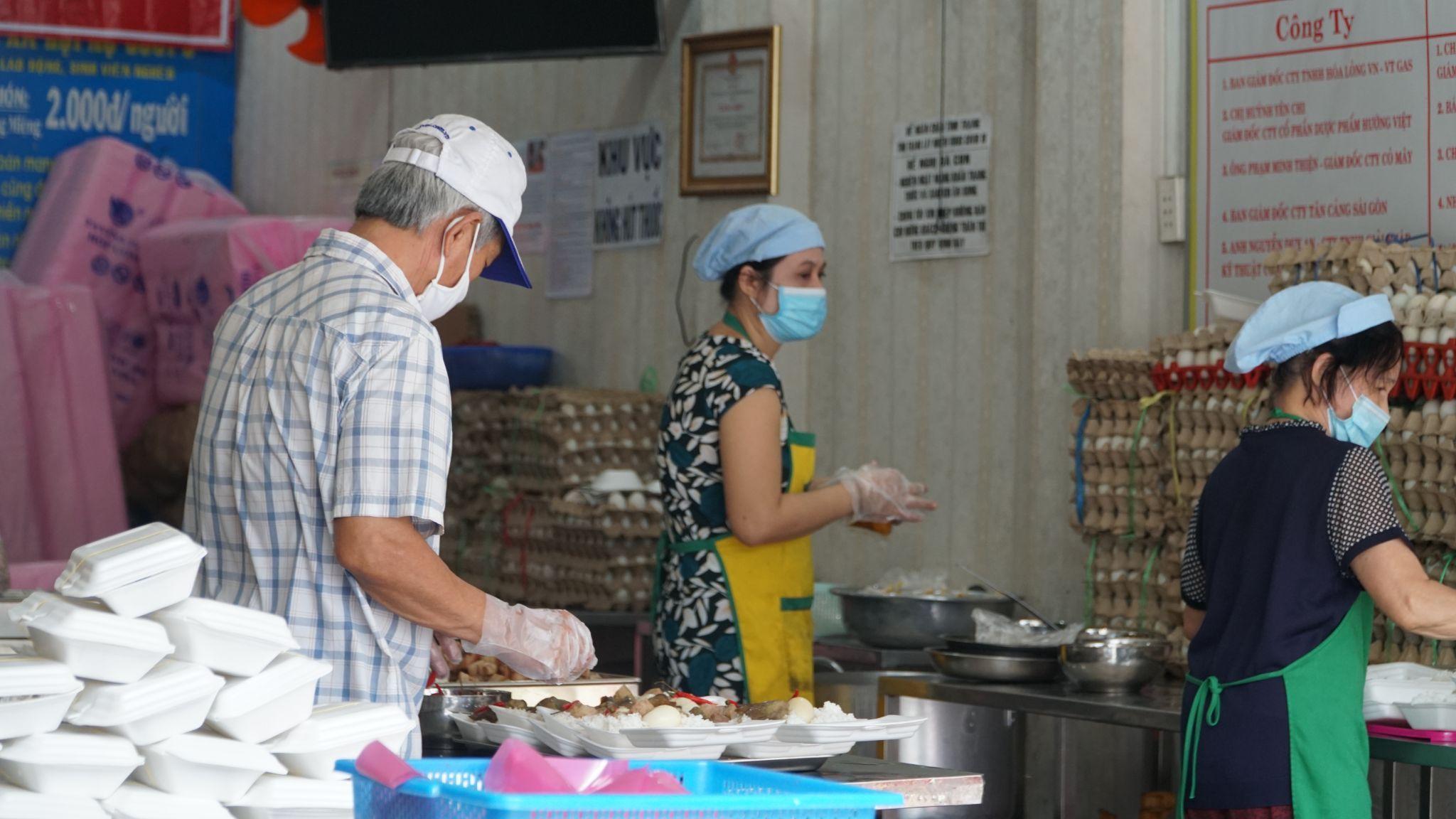 Tình nguyện viên tại quán cơm xã hội Nụ Cười chuẩn bị phần ăn miễn phí thuộc chương trình “Sài Gòn ơi, đừng bỏ bữa