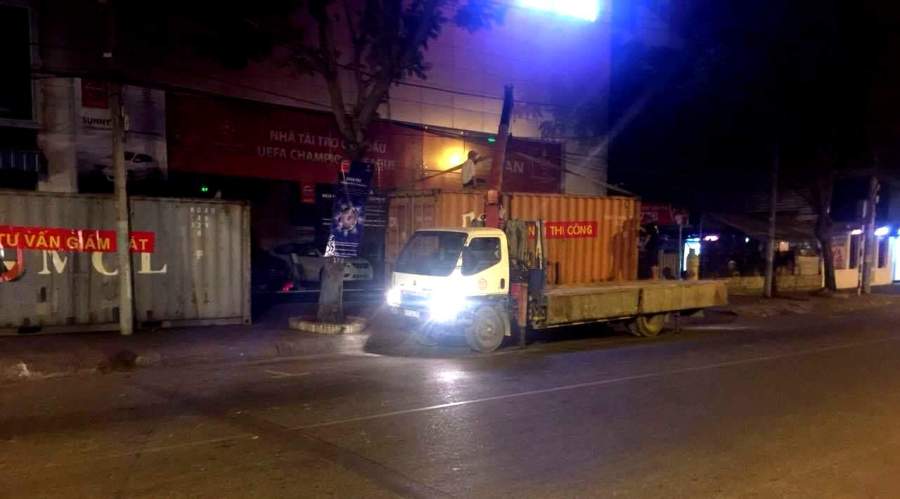 Sau khi báo Thanh Niên phản ánh, rạng sáng 13.3, Công ty Đức Bình đã cho xe tải đến di dời toàn bộ 9 container chắn dưới vỉa hè - Ảnh: Đàm Huy 