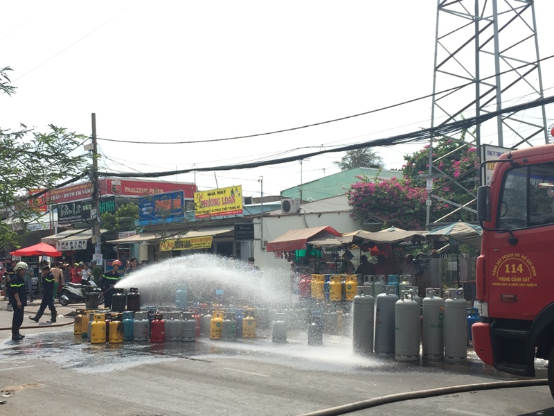 Hàng trăm bình gas bị cháy xém được lực lượng chức năng chuyển ra ngoài an toàn - Ảnh: Đức Tiến 