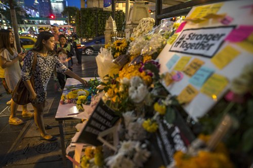 Một người phụ nữ đặt hoa tưởng niệm các nạn nhân thiệt mạng trong vụ đánh bom tại đền Erawan, thủ đô Bangkok, Thái Lan - Ảnh: Reuters