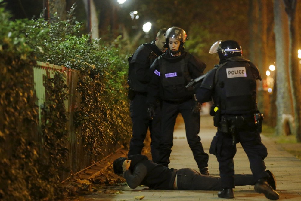 Một người đàn ông nằm sấp để cảnh sát Pháp kiểm tra giấy tờ gần nhà hát Bataclan, sau vụ nổ súng chết người ở Paris - Ảnh: Reuters