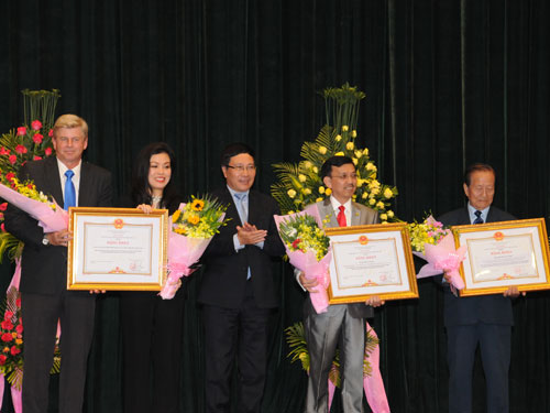 Phó thủ tướng kiêm Bộ trưởng Bộ Ngoại giao Phạm Bình Minh tặng bằng khen cho 1 tập thể và 2 cá nhân kiều bào - Ảnh: H.Thúy