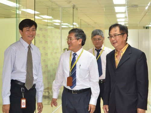 Ông Nguyễn Quốc Hùng (bìa phải) đưa khách tham quan Công ty LogiGear VN - Ảnh: M.P