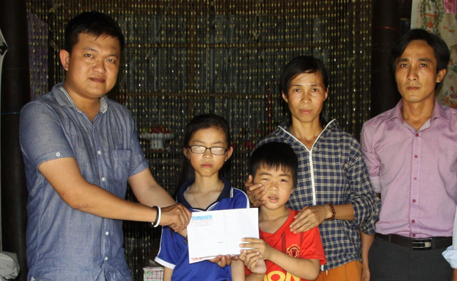 Đại diện Báo Thanh Niên (bìa trái) trao tiền cho gia đình chị Hoàng Thị Bích Nga	ẢNH: NGỌC VŨ