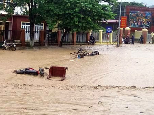 Nước lũ cuốn trôi xe máy, đồ đạc người dân trên đường phố tại thị trấn Tuần Giáo (Điện Biên) - Ảnh: Điện Biên