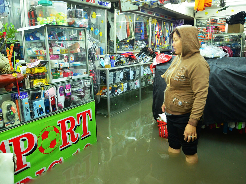 Nước tràn vào các cửa hàng buôn bán ở đường An Dương Vương (Q.Bình Tân) - Ảnh: Đức Tiến