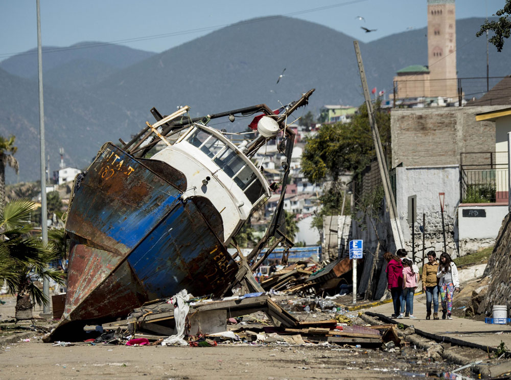 Tàu đánh cá bị quét lên đường phố Coquimbo - Ảnh: AFP