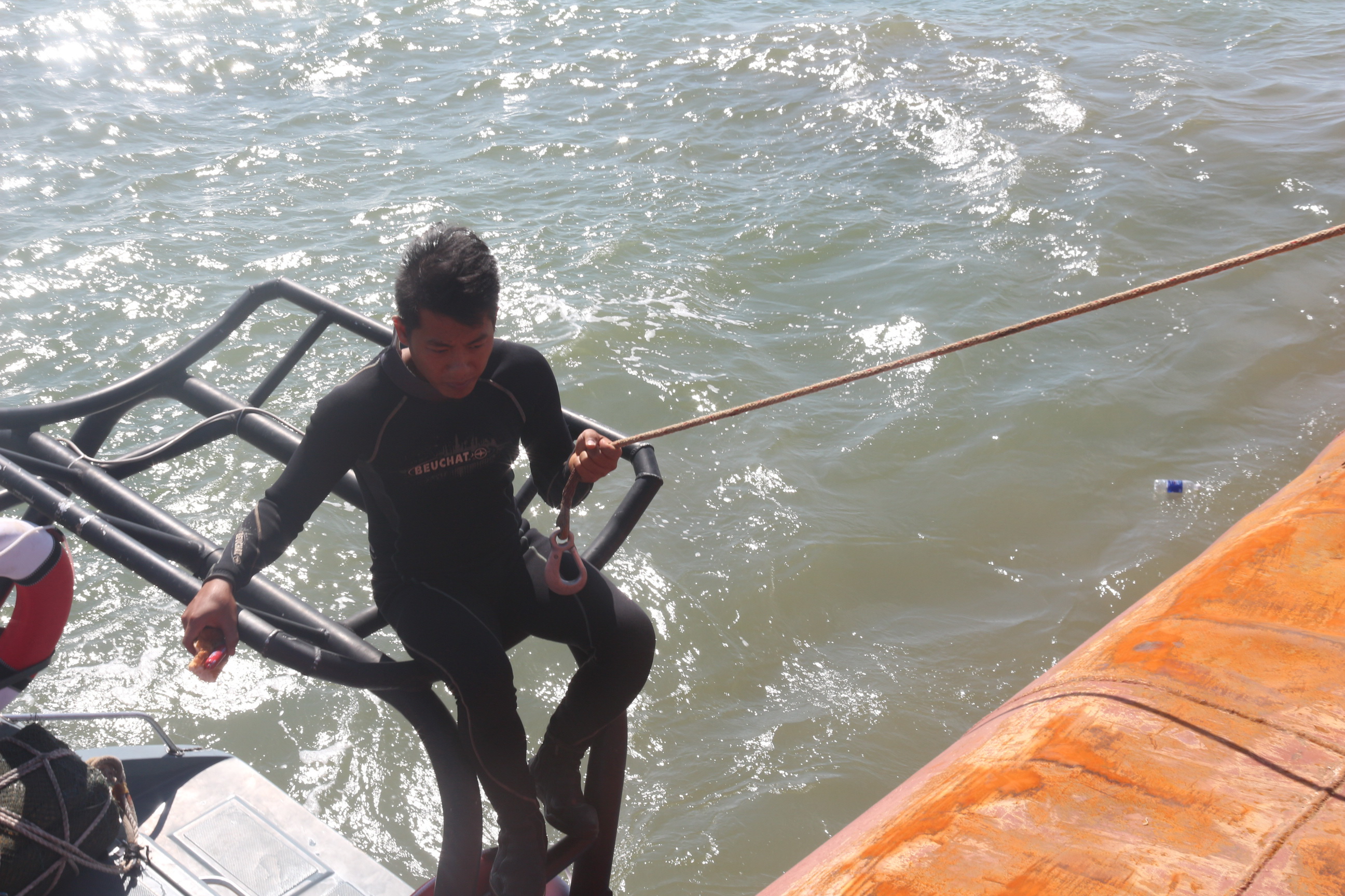 “Người nhái” đu dây chuẩn bị công việc lặn xuống nước để tìm kiếm